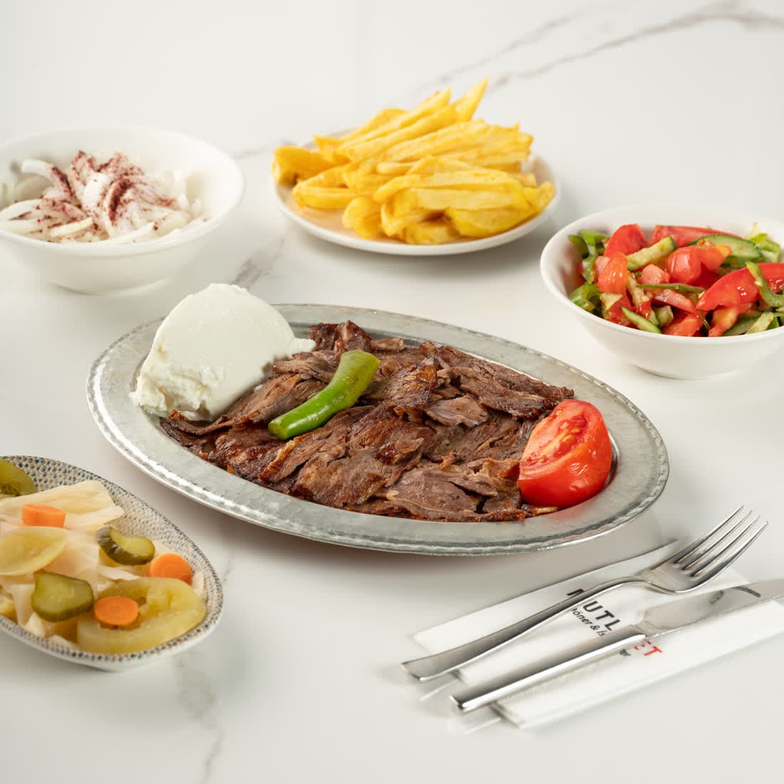 Mutlu Et İskender kebap: bakır tepside döner, domates sosu ve kızdırılmış tereyağıyla tamamlanmış porsiyon